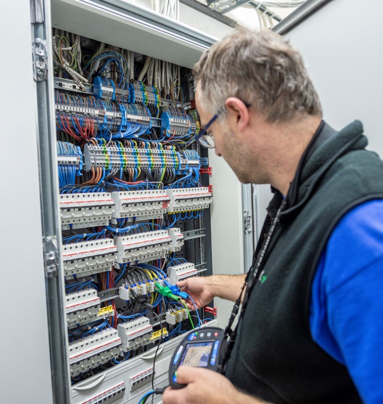 Facharbeiter beim e-Check Messarbeiten am Elektroschrank